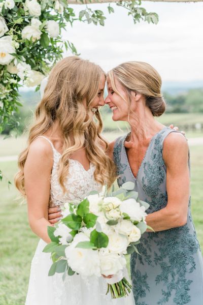 Close up of bride and mother holding bouquet of flowers exterior shot