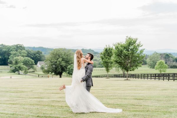 Groom picking bride up exterior farm shot tree veil train dress detail lace