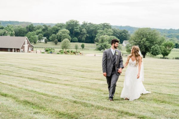 Couple holding hands exterior farm forest park looking at each other