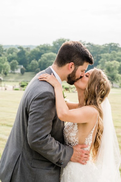 Kissing couple exterior forest park veil dress detail landscape