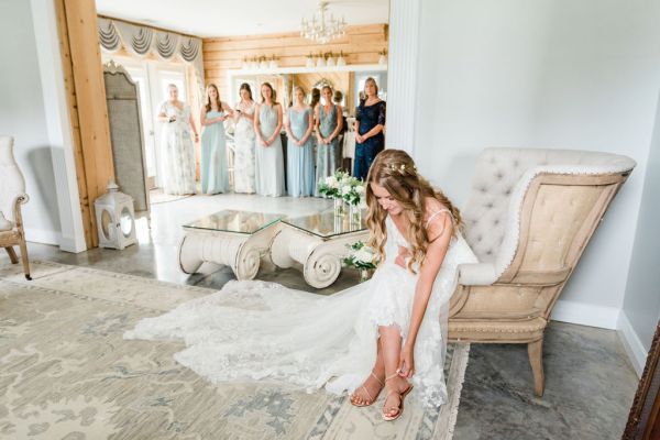 Close up of sandals shoes bride lace dress flowers sitting down white nail varnish mirror bridesmaids getting ready