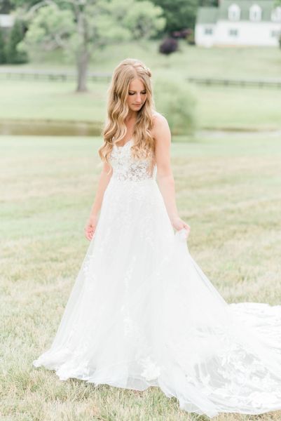 Long train dress bride lace dress detail looking down exterior grass farm