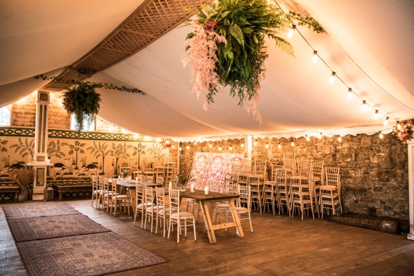 Eoin & Darran Real Wedding interior photography tent overhanging flowers floral design chairs dining dance floor