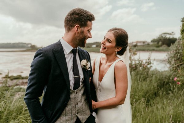 bride and groom on beach and grass