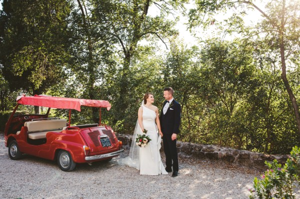 Bride groom caddy car exterior sunshine bouquet of flowers looking at each other