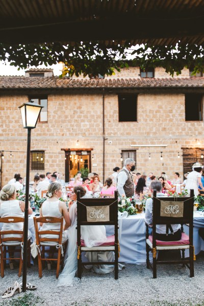 Daytime shot table setting guests exterior lamppost shoes heels drinks food