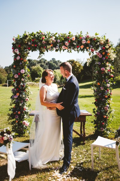 Just wed bride groom couple exterior flowers decor happy wedding smiling