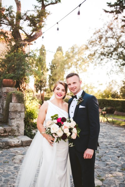 Smiling couple bride groom flowers exterior bouquet just wed