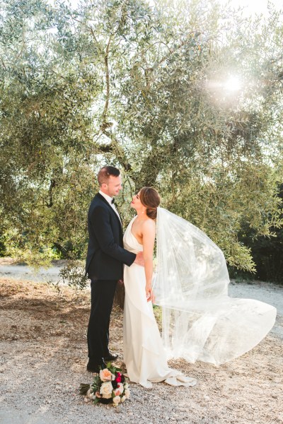 Bride groom couple photography just wed married flowers bouquet veil blowing in the wind