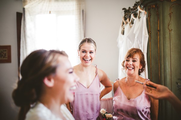 Getting ready bride laughing smiling hair makeup MUA flower detail bridesmaids pink dresses