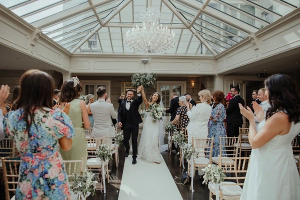 Clapping just wed bride groom ceremony holding hands