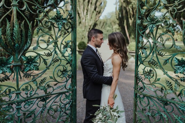 Gate ajar open couple standing bouquet of flowers just married wed