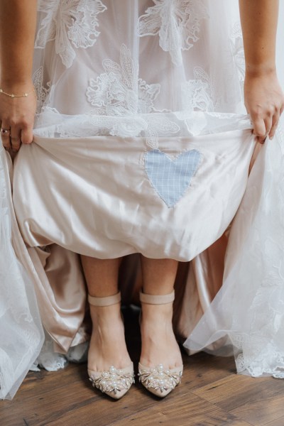 Bride shows something blue - material heart stitched into wedding dress Olga Hogan Photography: Hannah & Eoghan