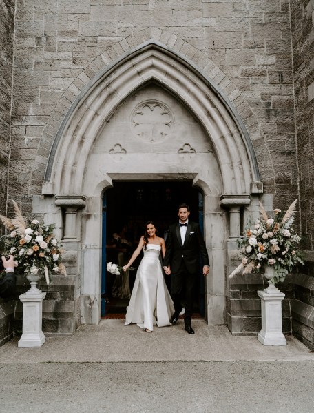 Bride and groom exist church ceremony married just wed bouquet of flowers exterior shot