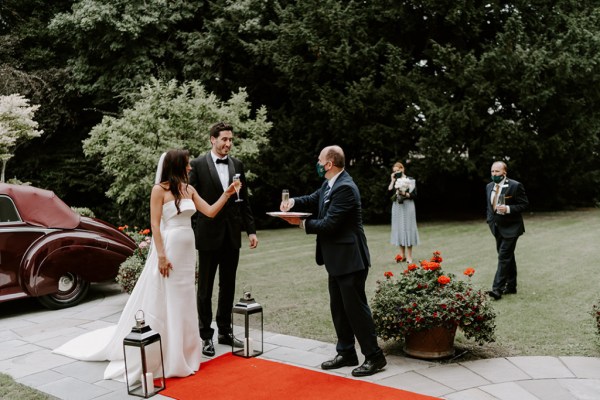 Bride groom drinking champagne prosecco red carpet lanterns exterior church