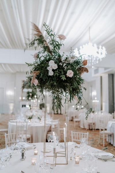 Interior white dining wedding venue chandelier food dinner flowers bouquet table