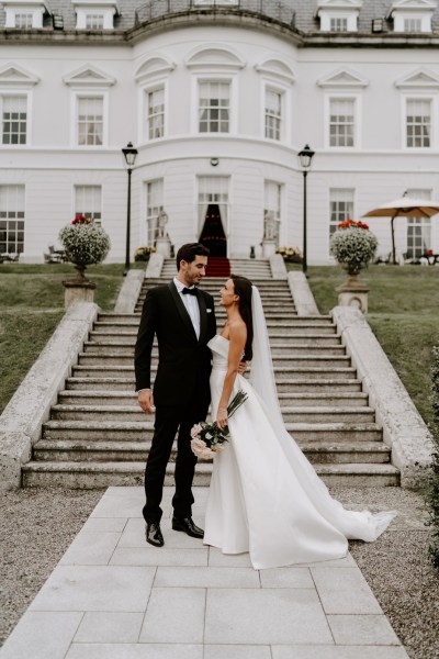 Bride and groom exterior steps hotel pink white roses