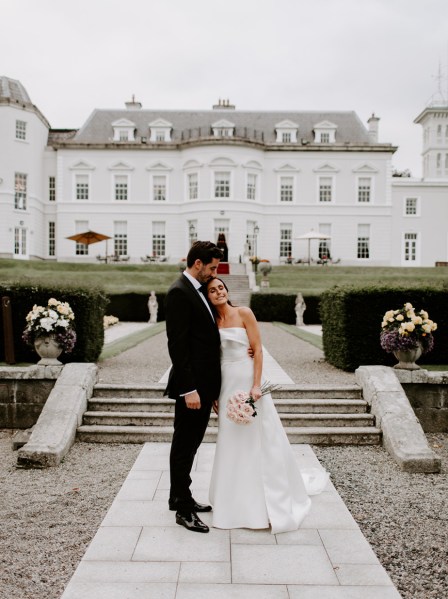 Bride and groom exterior steps hotel pink white roses flowers bouquet