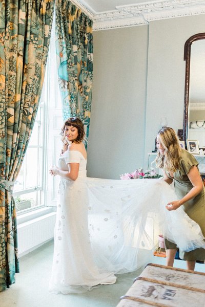 bride getting ready with bridesmaid