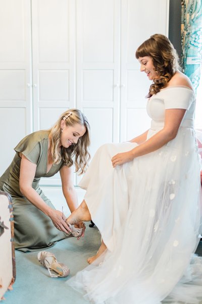 bride getting ready with bridesmaid