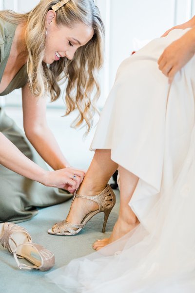 bride getting ready with bridesmaid