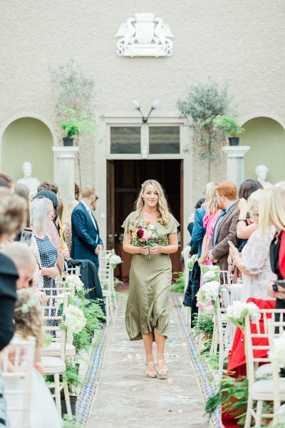 green olive bridesmaid walking up aisle