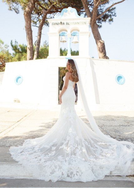 Bride on her own veil train detail white dress exterior before ceremony looking over shoulder