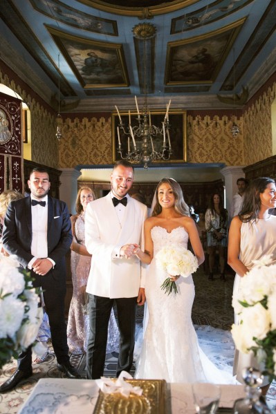 Bride and groom white dress suit black tie guests interior church