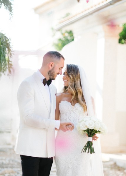 Interior bride and groom embrace ceremony bouquet of flowers