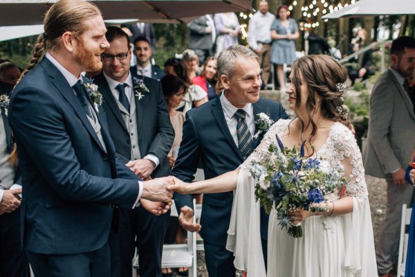 Father of the bride giving his daughter away to groom at alter ceremony