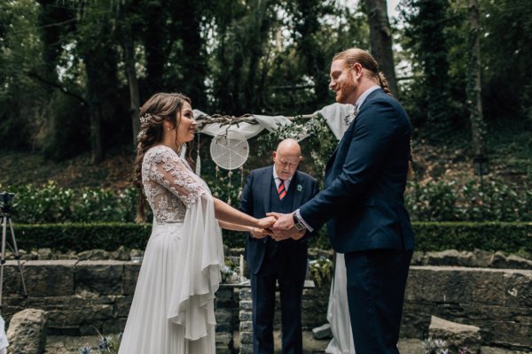 Bride and groom hold hands wedding ceremony