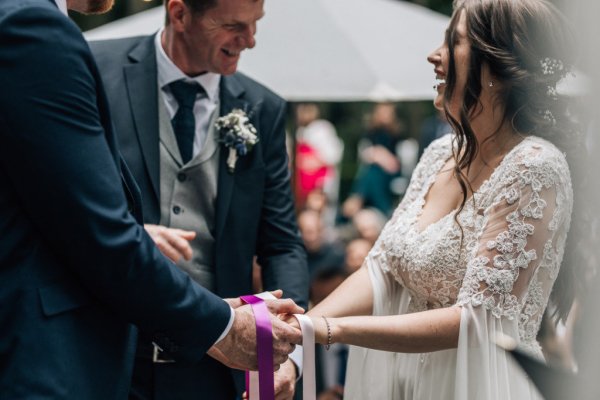 Bride and groom bound in ribbon wedding ceremony