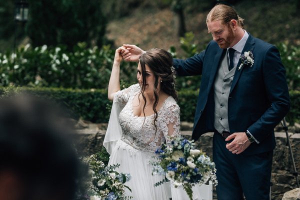 Bride holding bouquet flowers holding hands