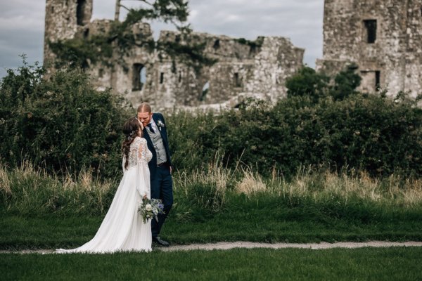 Bride and groom walk the grounds of the castle flowers bouquet