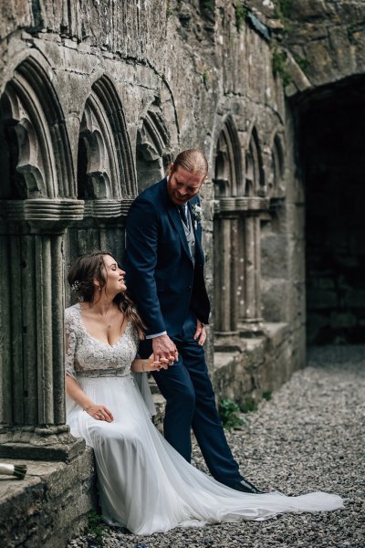 Bride sitting castle exterior groom