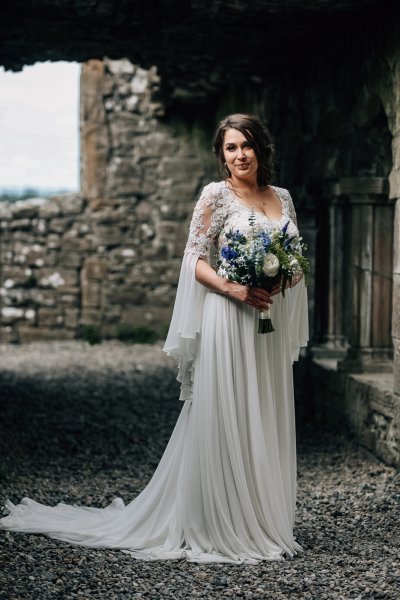 Bride exterior castle holding flowers bouquet