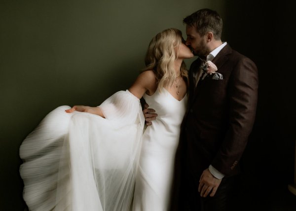 Bride and groom kiss on stairs