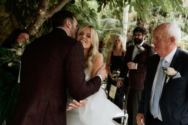 Bride and groom smile embrace