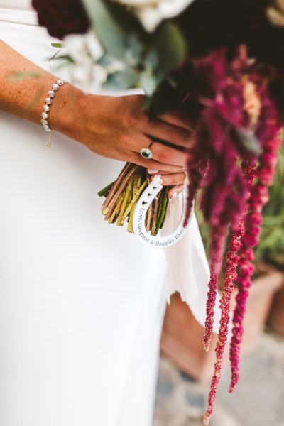 bridal bouquet with red pink flowers and horseshoe charm