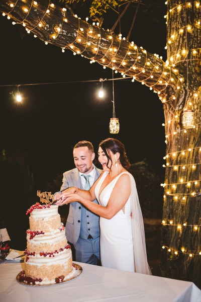 bride and groom couple cut cake with cute topper