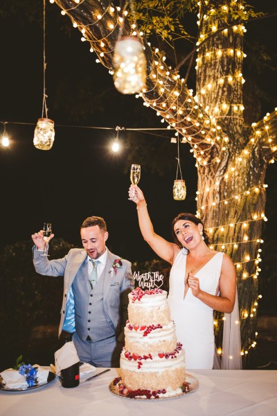 bride and groom couple cut cake with cute topper