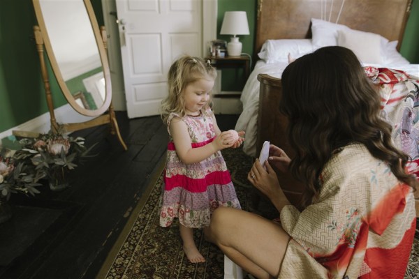 flower girls getting gift or present from bride morning of wedding