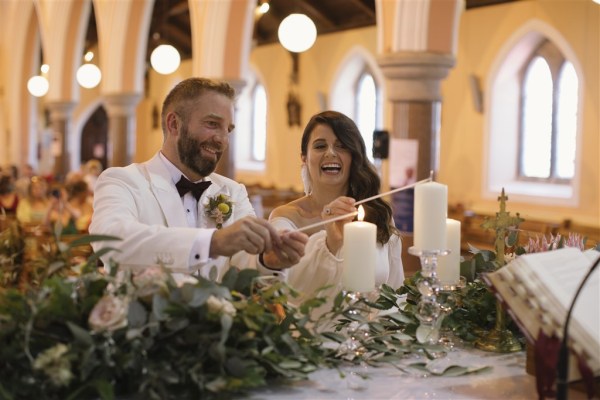 bride and groom light candle