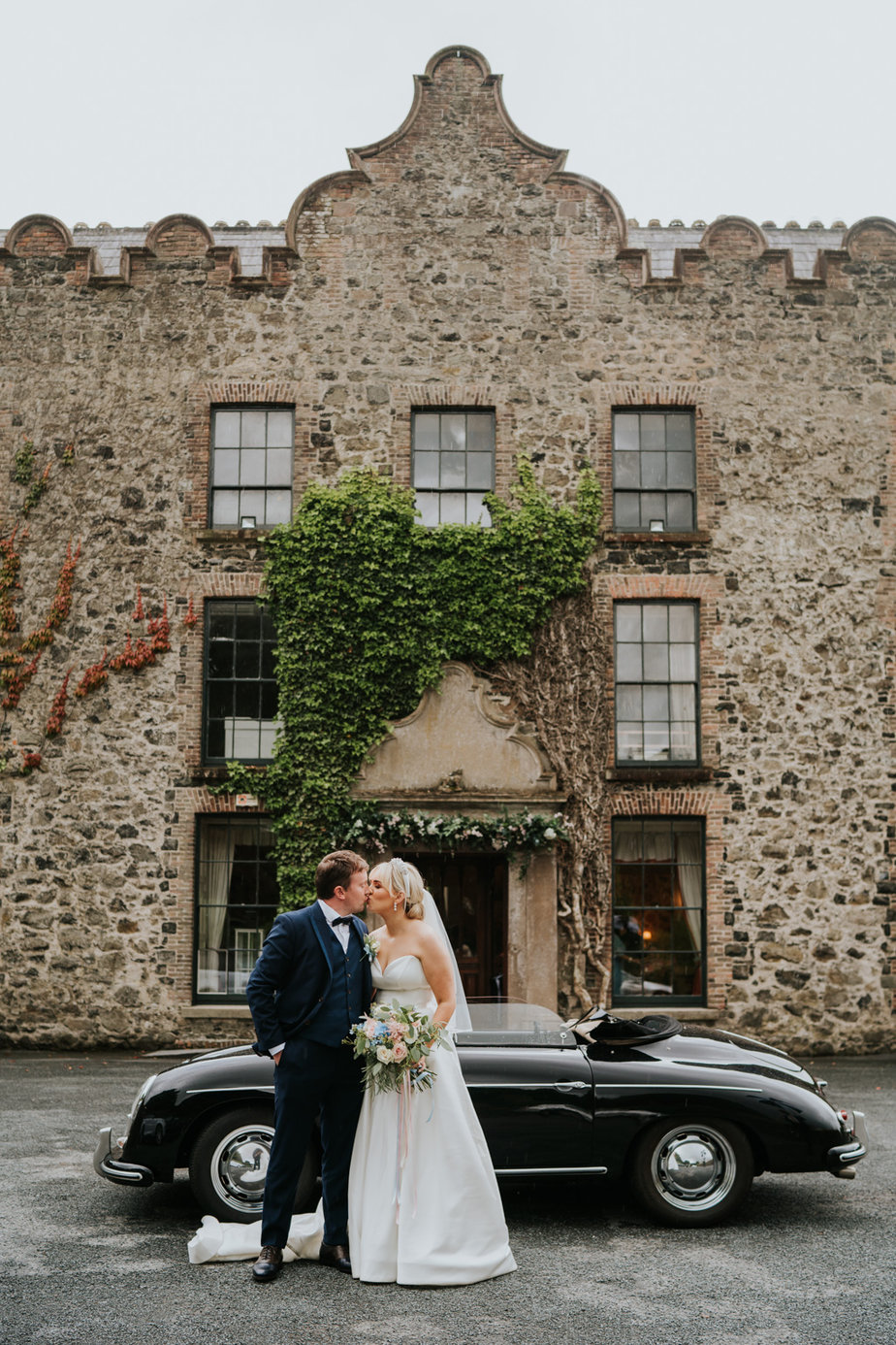 bride and groom with wedding car