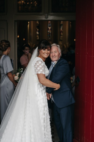 Bride and father hug