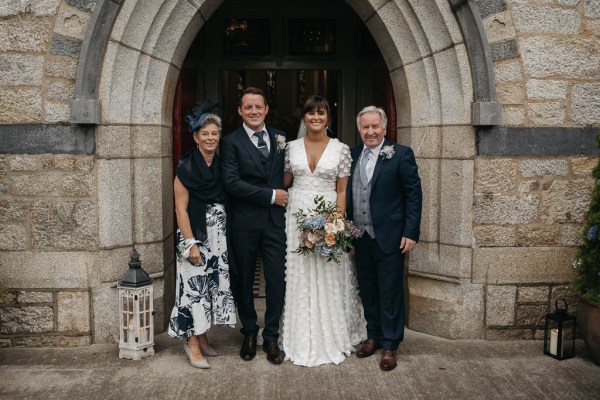 Bride groom family mother father bouquet of flowers roses outside exterior chapel/church