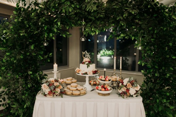 wedding cake on dessert table with donuts and cupcakes