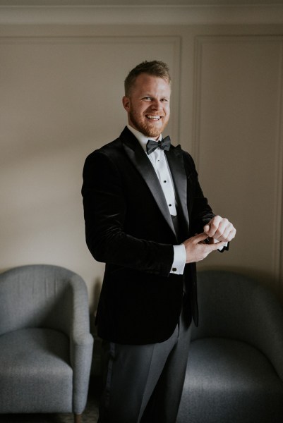 Groom gets ready in room shirt cufflink detail