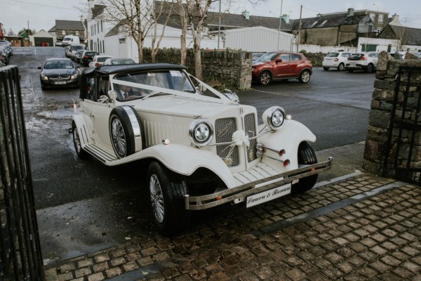 White wedding car sits outside church