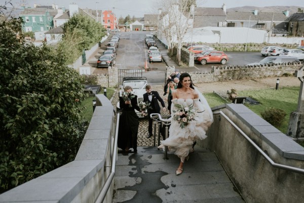 Bride and her bridesmaids walk up the steps to church